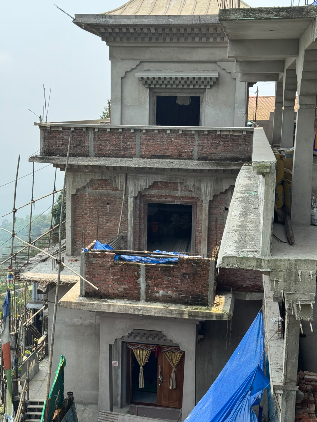 Upper floors of the Dolma-Ling temple — carved statue niches and traditional pagoda roof