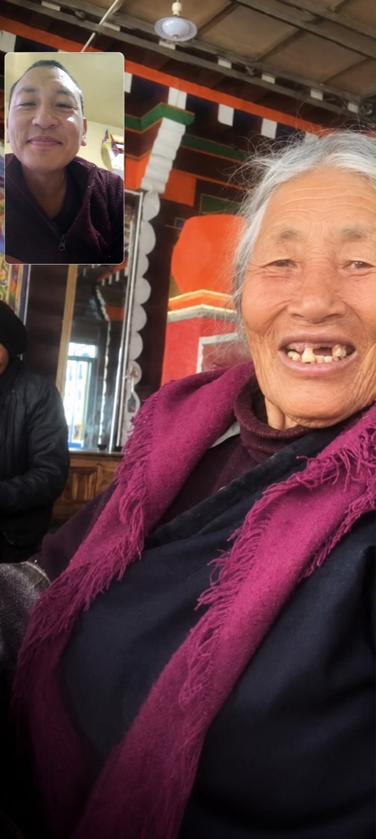 A video call between Geshe-la and his smiling elderly mother in Tibet
