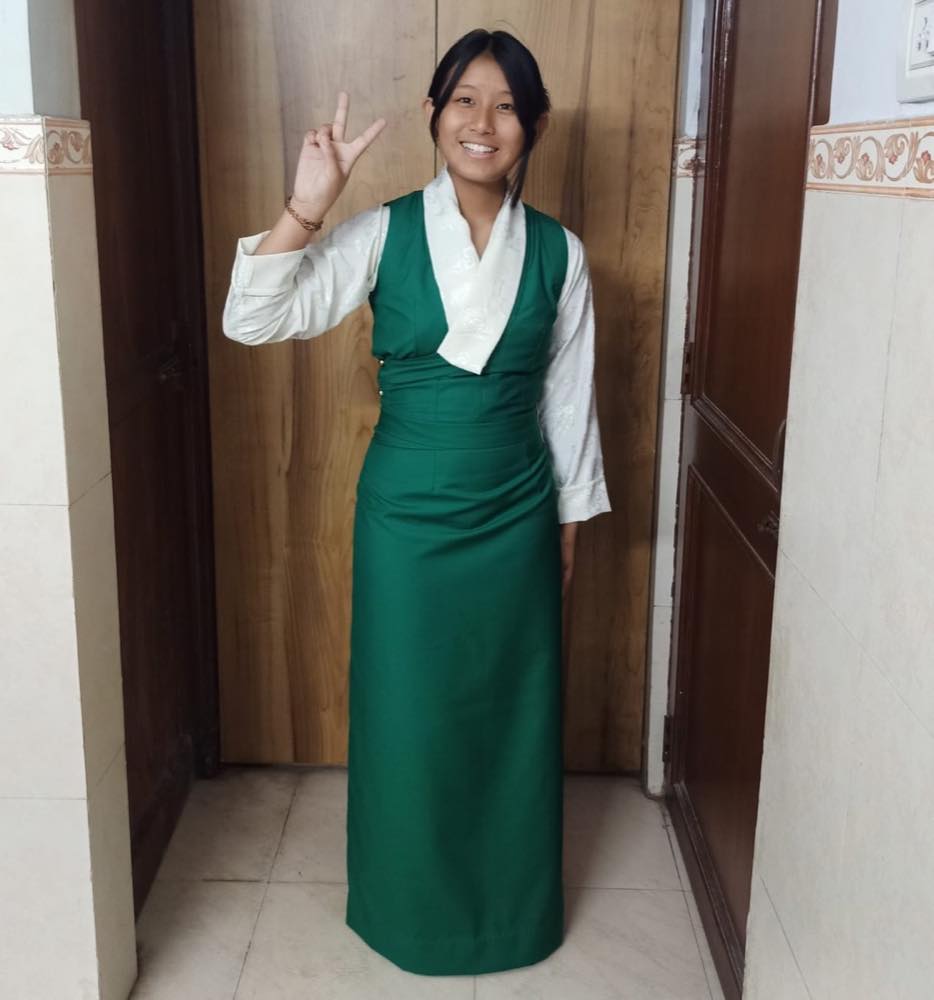 In traditional Tibetan dress, the young woman she has become