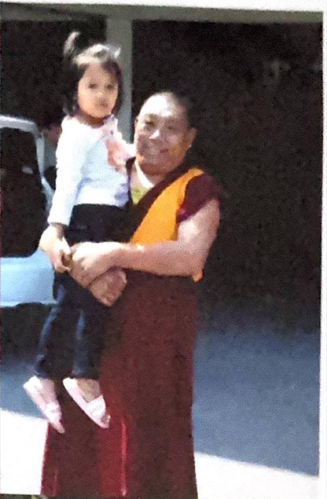Geshe Lobsan Gyaltsen holding her as a toddler