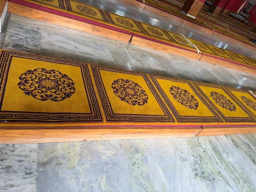 Gold brocade seating mats laid out in the prayer hall