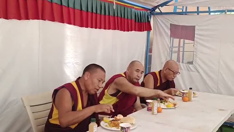 Monks sharing a meal together under the retreat tent