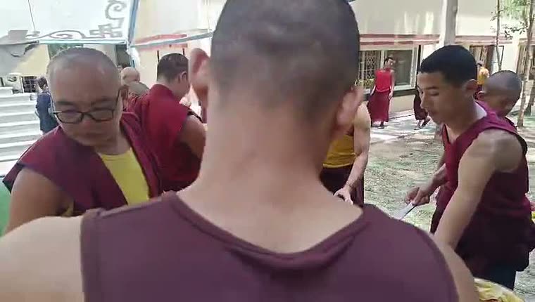 Young and senior monks filling their plates along the serving line